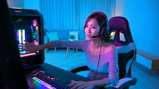 En bekymret kvinne sitter foran en gaming-PC