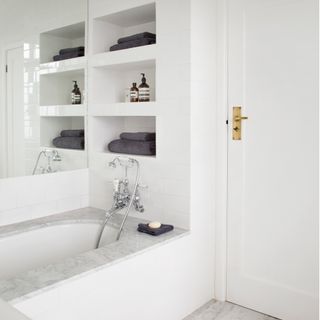 bathroom with white wall bathtub white door