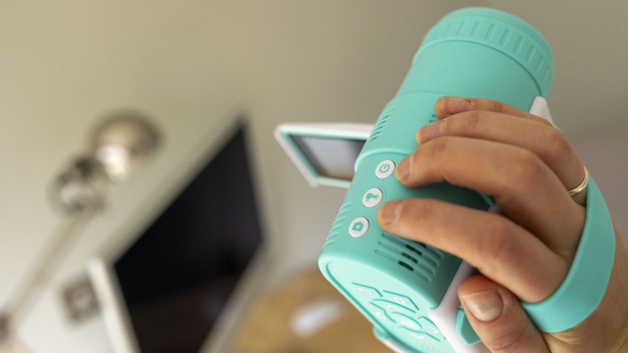 The Photo Creator projector video camera being handled in a home office
