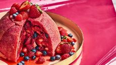 a big dome of summer pudding, cut open with berries spilling out