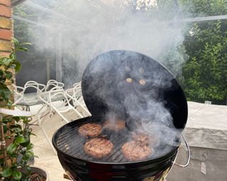 Weber Smokey Joe BBQ cooking burgers with smoke