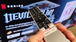 Remote control pointing at a TV with Netflix on the screen