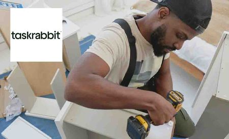 task rabbit logo top left with a man drilling a cabinet 