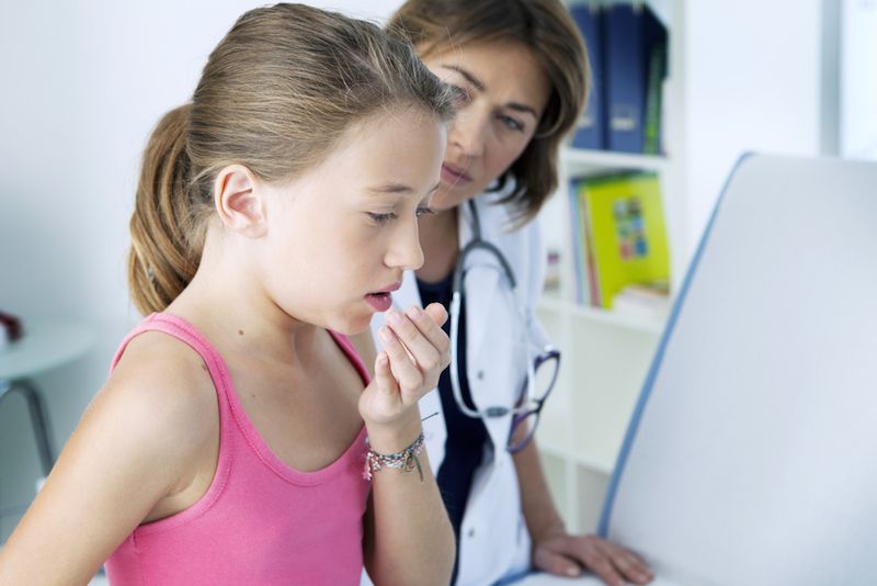 Girl coughing at the doctor&#039;s office