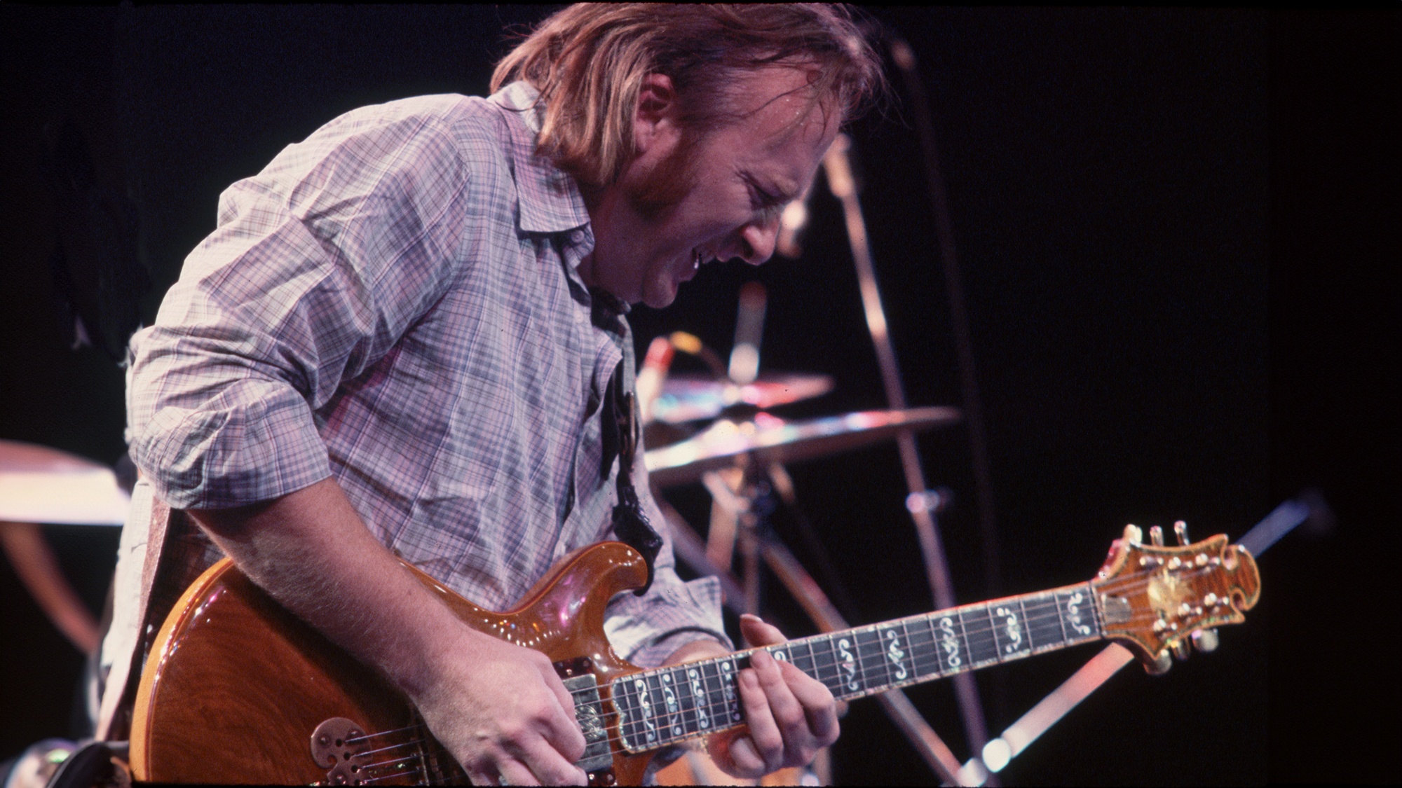 Stephen Stills plays guitar in concert with his band Crosby Stills and Nash, 1970