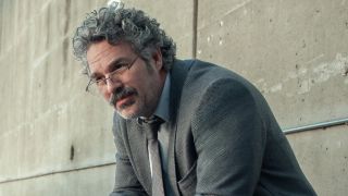 Mark Ruffalo leaning while sitting and wearing glasses in Crime 101. 