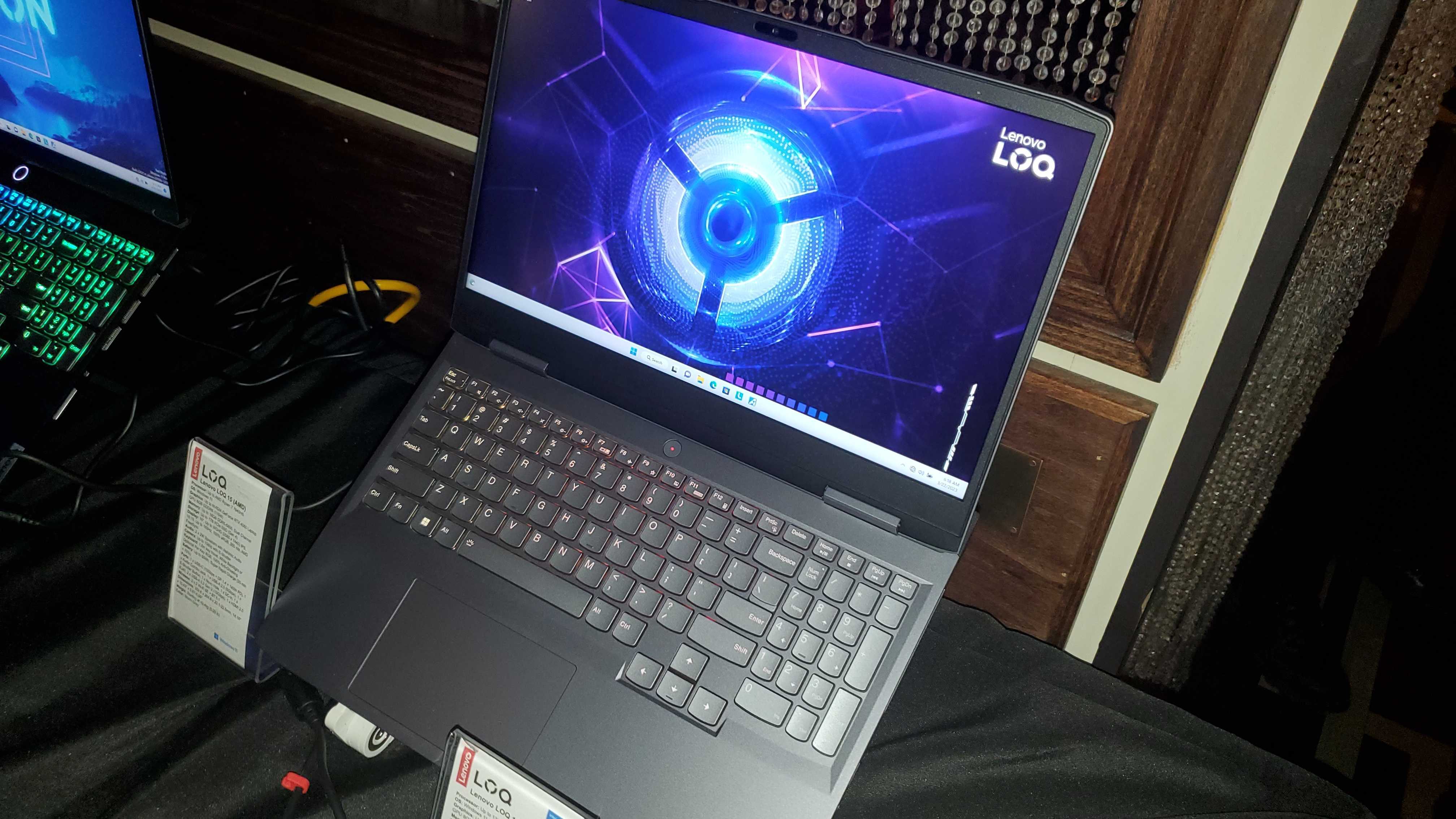 dark laptop with RGB lighting, display showing logo