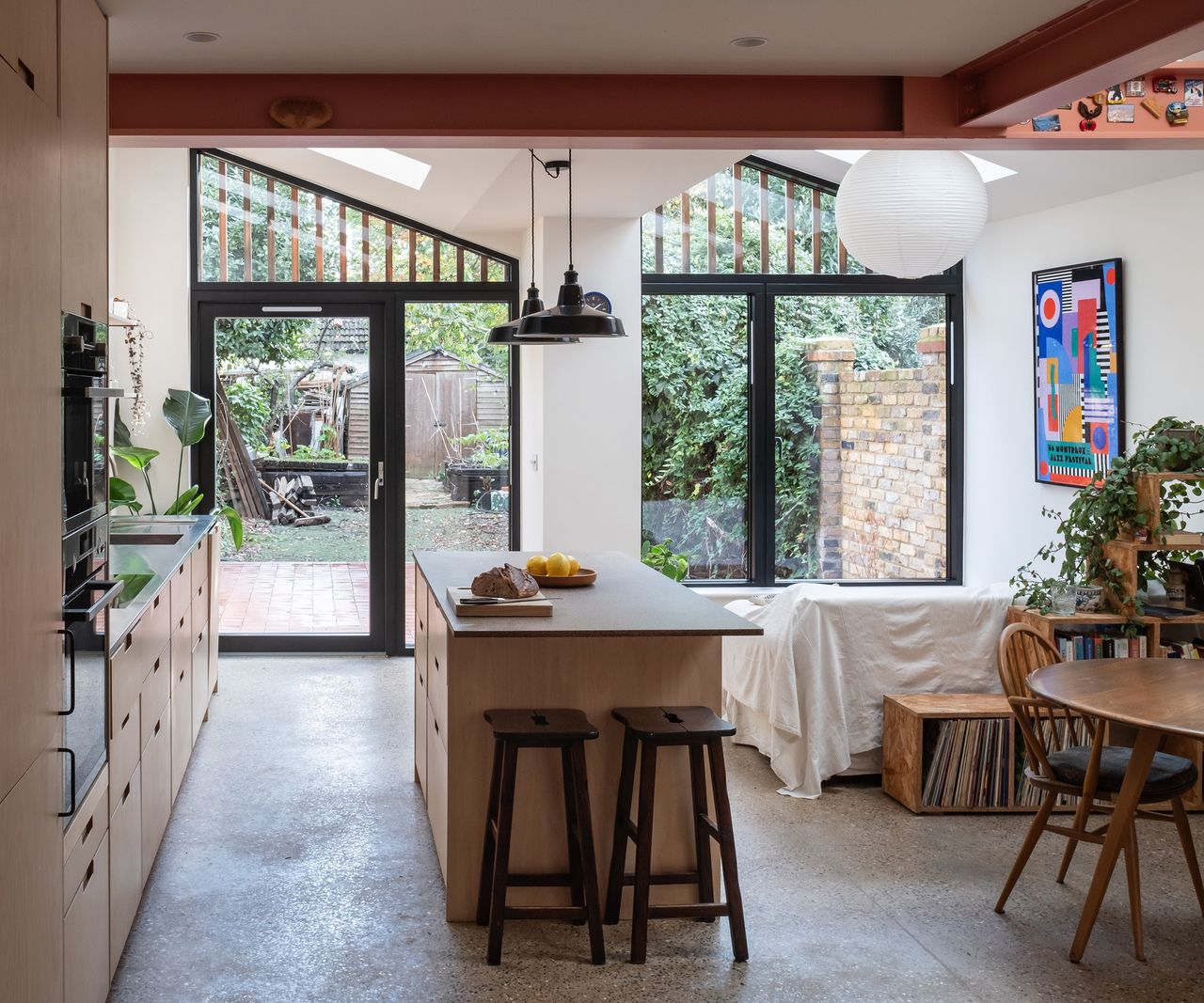 An open plan kitchen and dining room area with a view out of glazing into a back garden