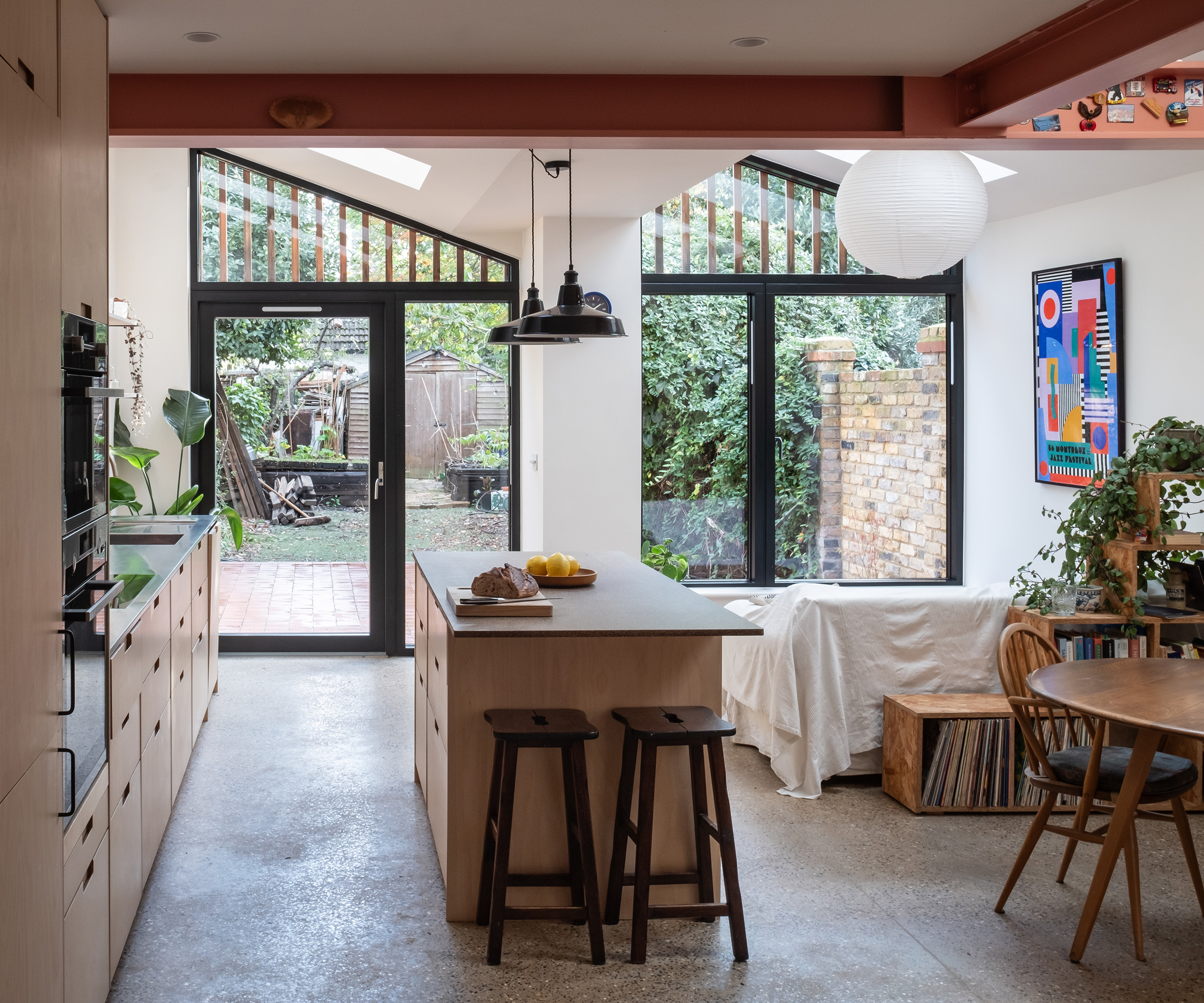 An open plan kitchen and dining room area with a view out of glazing into a back garden