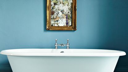 Free standing bathtub in blue painted bathroom