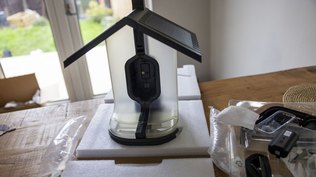 The FeatherSnap Scout bird feeder being unboxed on a wooden dining table