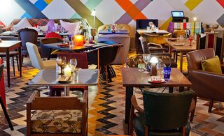 Gallery restaurant with geometric zigzag floor and different colour stripes painted on walls