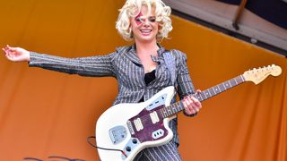 Samantha Fish wears a pin-stripe suit and plays an Olympic White Fender Jaguar