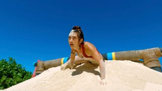 Savannah Louie crawling under a log and through sand during an intense Survivor Season 49 challenge.