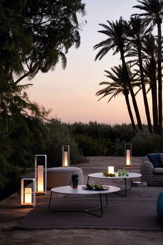 Manutti Flame LED lights from Go Modern in a modern outdoor garden with a sunset in the background