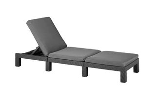 A rattan-effect sun lounger with dark grey cushions