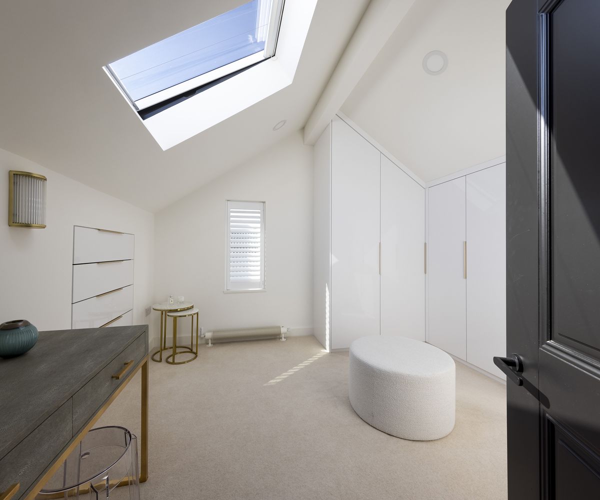 small bedroom slash office with build in storage in a loft extension with roof light