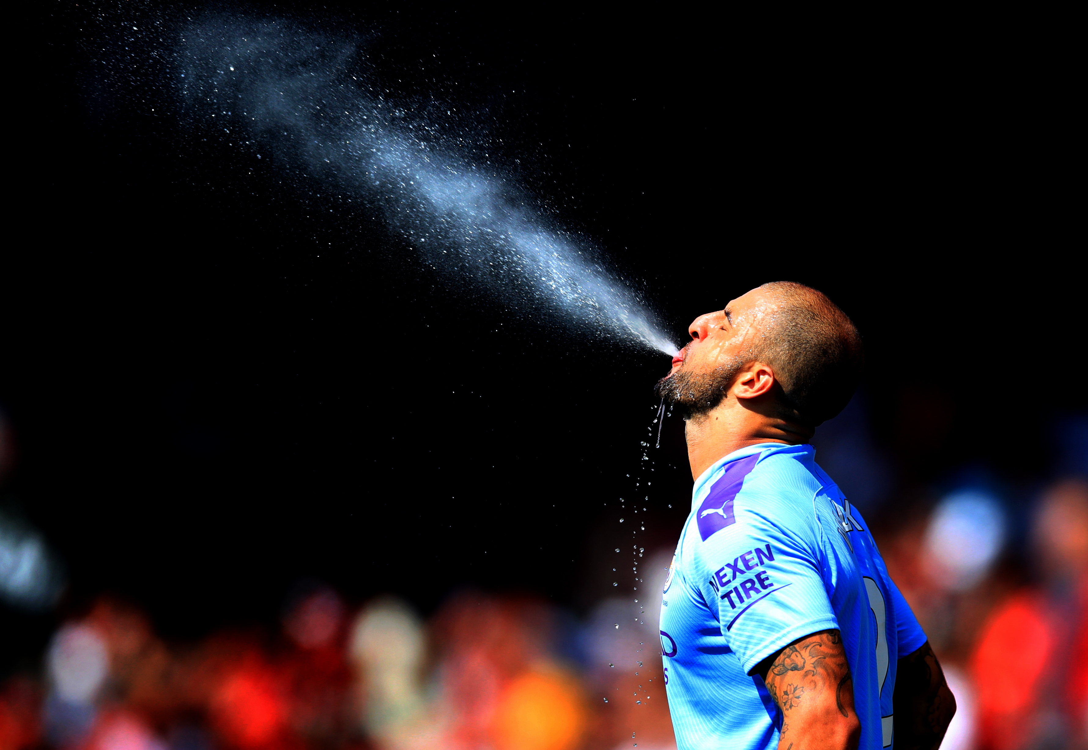 Manchester City’s Kyle Walker spits out water ahead of the match