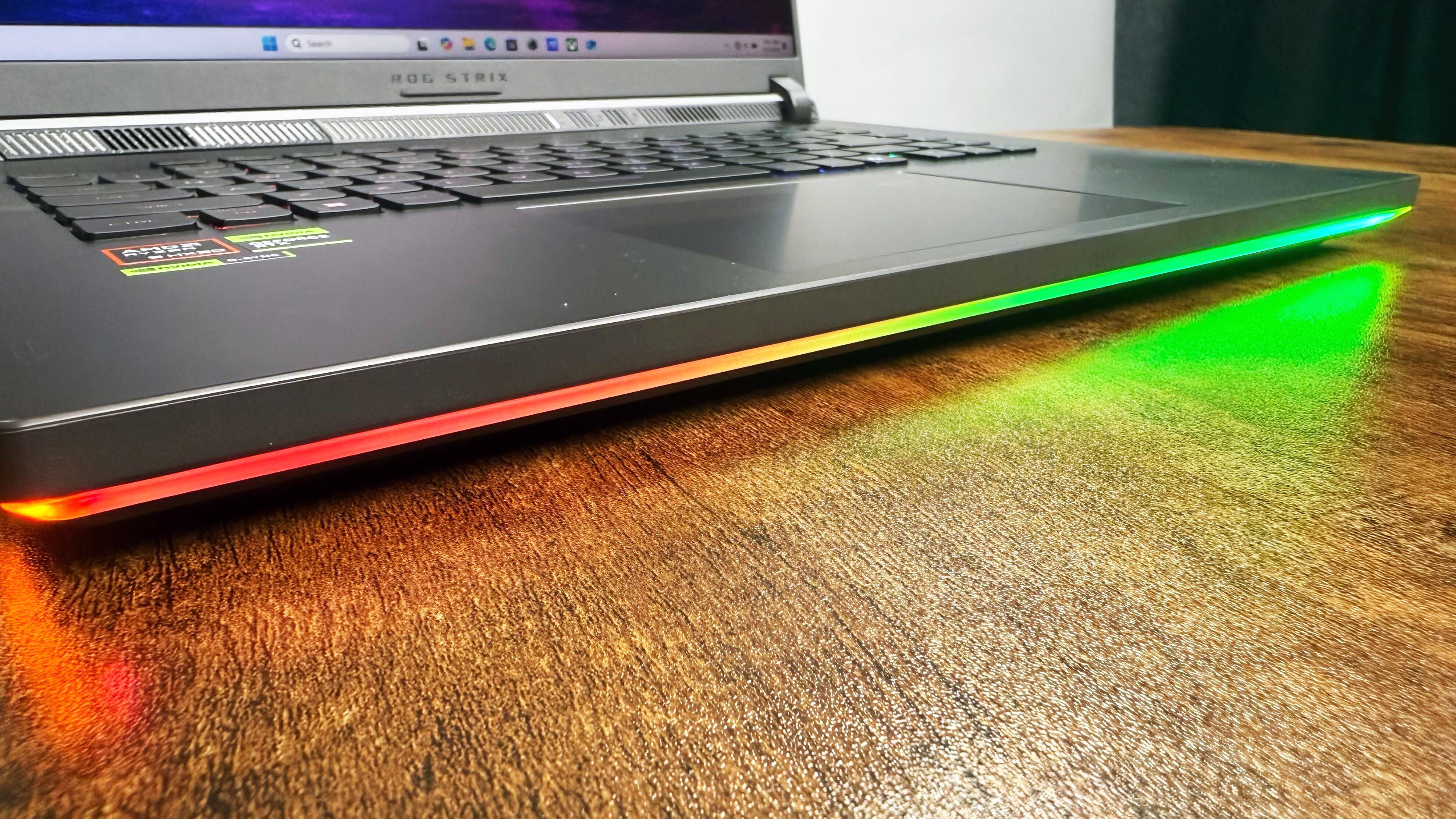 Close up of the RGB light bar beneath the keyboard deck of the Asus ROG Strix G16 (G614FR) gaming laptop.