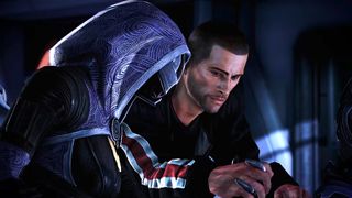 A hooded, masked figure in a patterned blue cloak faces a worried man in black, who cradles a small object in a dim, tense room.