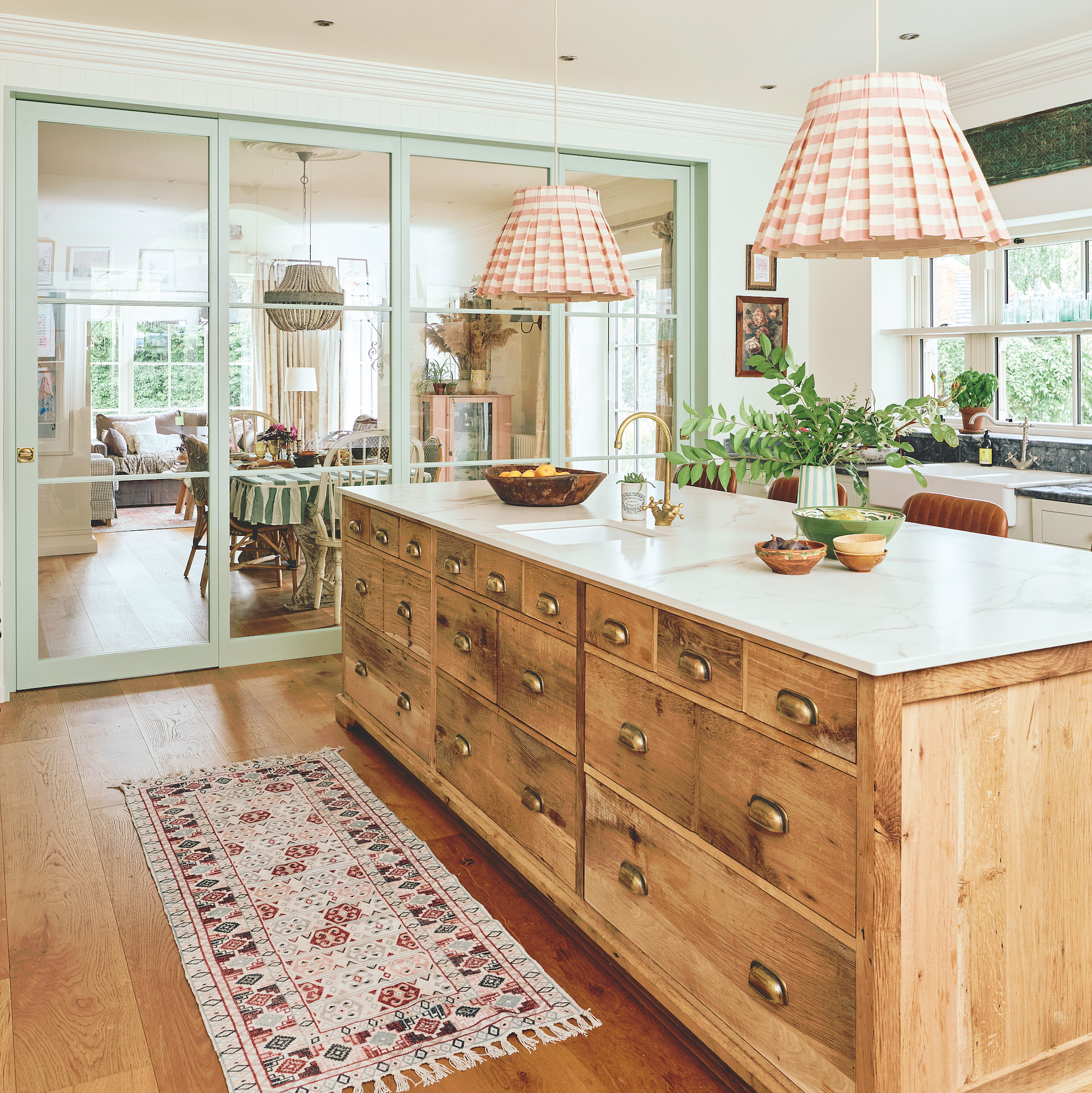 kitchen island made from vintage apothecary unit with striped pendant light shades above