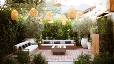 backyard with hanging lanters, festoon lights and firepit by Kate Anne Designs