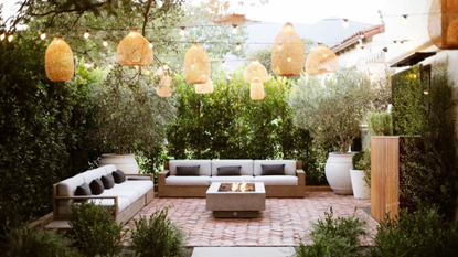 backyard with hanging lanters, festoon lights and firepit by Kate Anne Designs