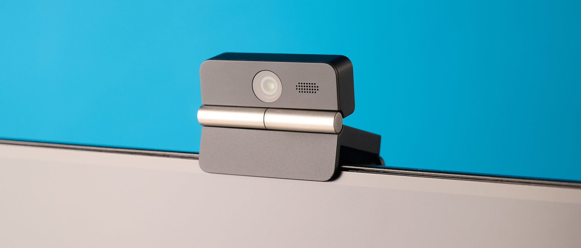 Obsbot Meet Flip foldable webcam photographed in front of a blue background