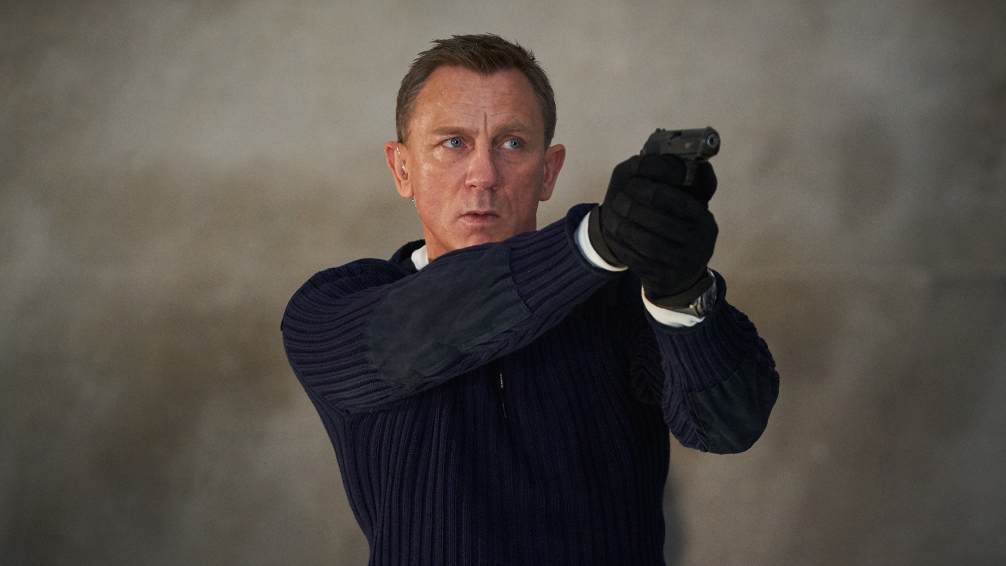 Daniel Craig's James Bond lines up a pistol shot in No Time to Die