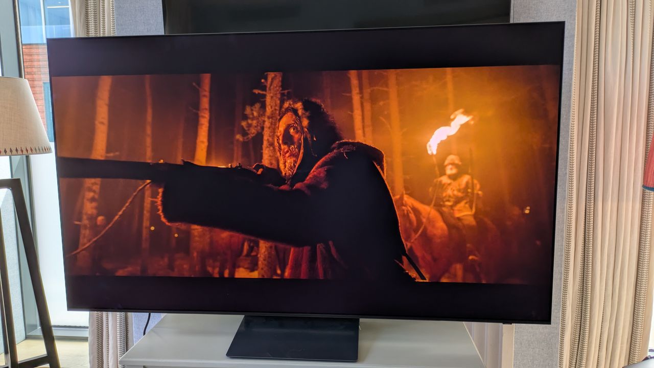 Samsung S90H OLED TV with man holding gun from The Revenant on screen