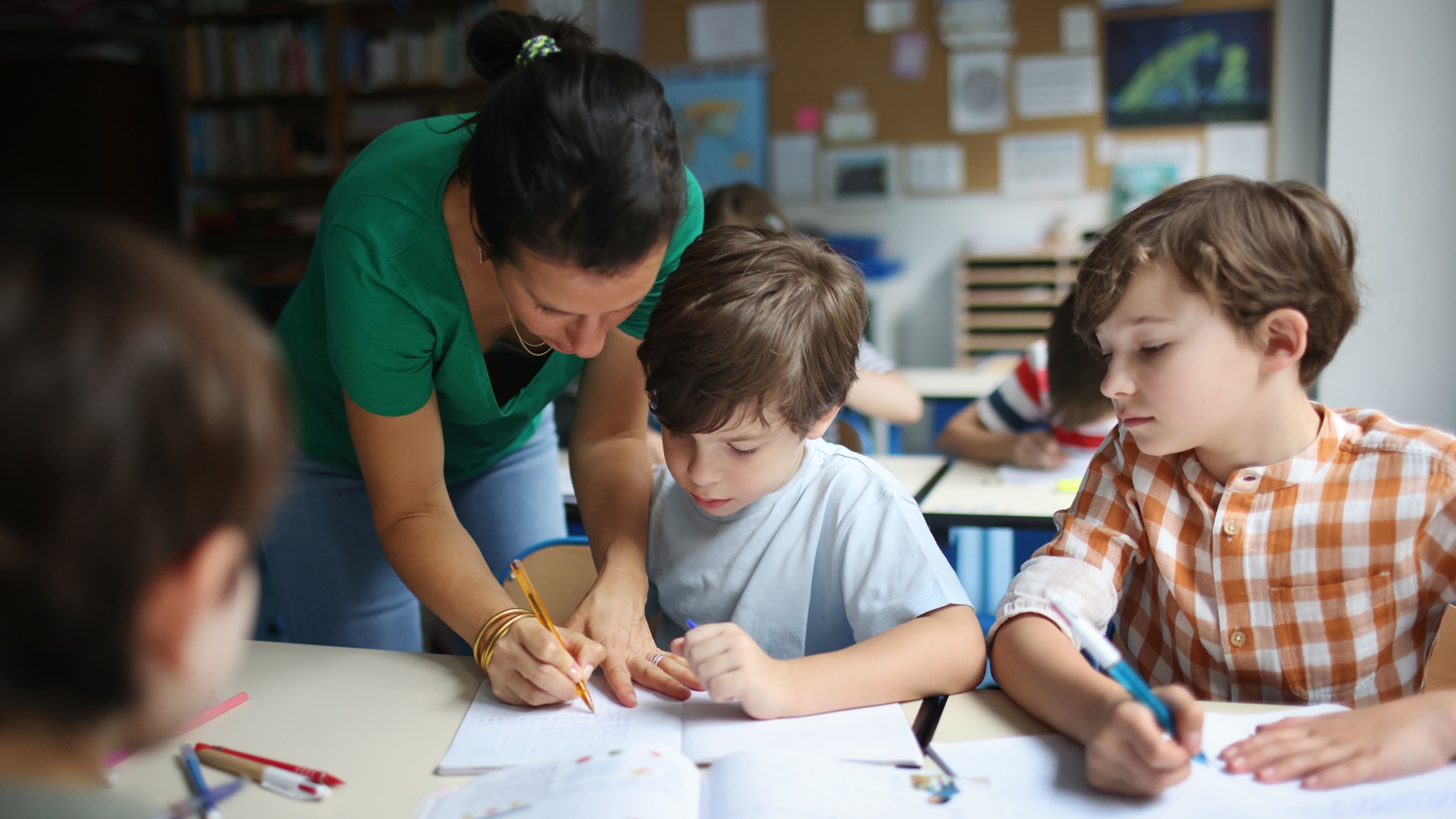 A teacher works with young students.