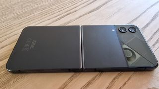 Galaxy Z Flip 4 ligger fladt på et bord - klappet ud med skærmen nedad