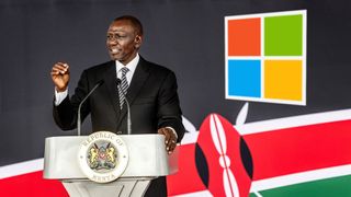 Kenya's President William Ruto delivers a speech at a podium with the Kenyan emblem. Behind him are the Kenyan flag and the Microsoft logo.