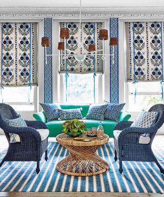 Living room ceiling light ideas with a white chandelier with rattan lampshades over bulbs, over seating area in blue bohemian room