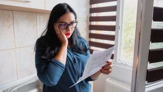 A woman looking at her energy bill. As the cost of living rises, just glancing at your energy bill could be enough to send you into depression.