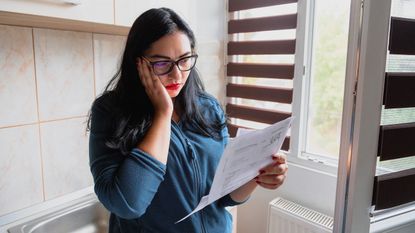A woman looking at her energy bill. As the cost of living rises, just glancing at your energy bill could be enough to send you into depression.