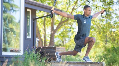 Premium Photo  Fitness couple doing arms exercise with trx fitness straps  in park. multi-ethnic people exercising outdoors.