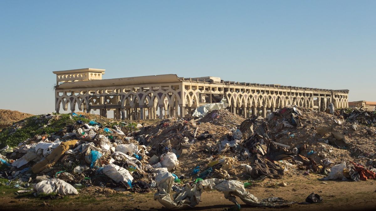 A garbage dump in front of a building ruined by war at Yasser Arafat International Airport in the Gaza Strip.