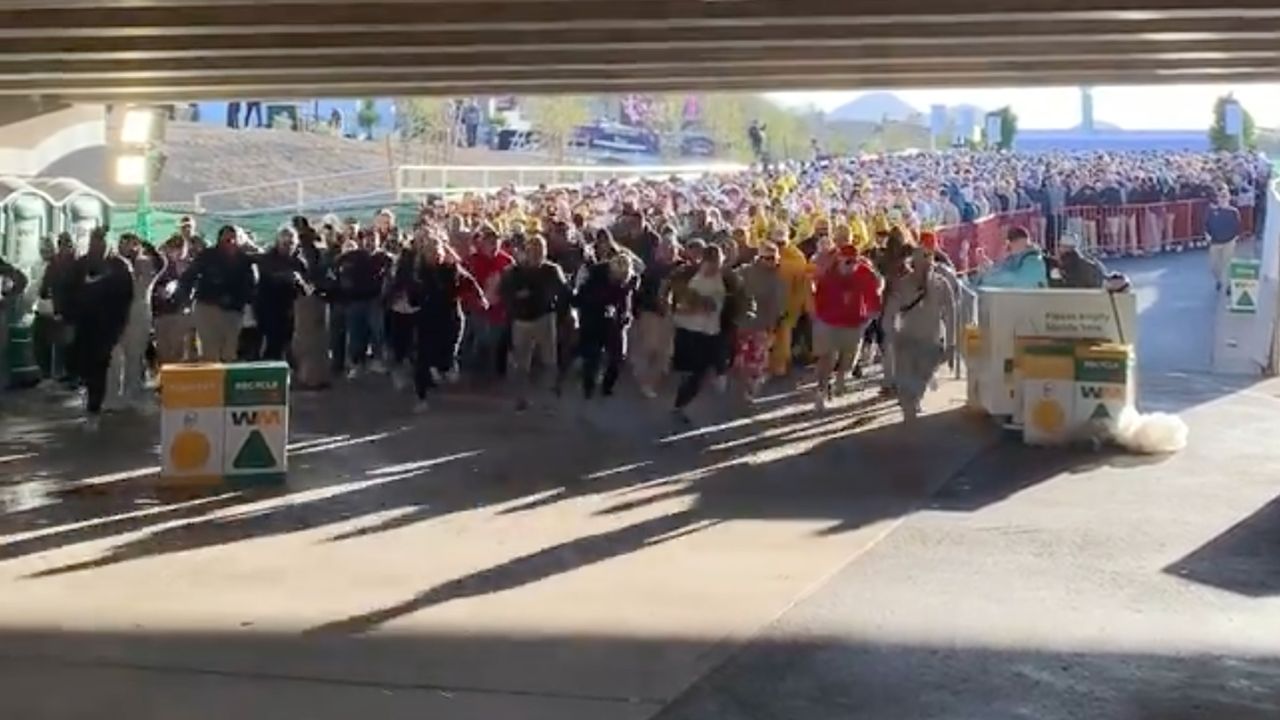 Fans begin to run towards the 16th hole at TPC Scottsdale