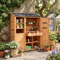 garden cabinet used instead of a shed in a garden to store gardening tools