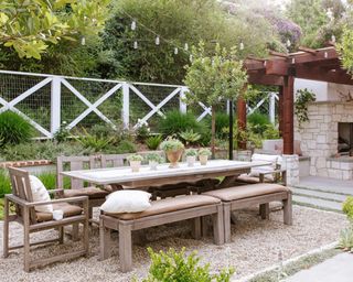 A sunken outdoor dining area with a pergola in the background
