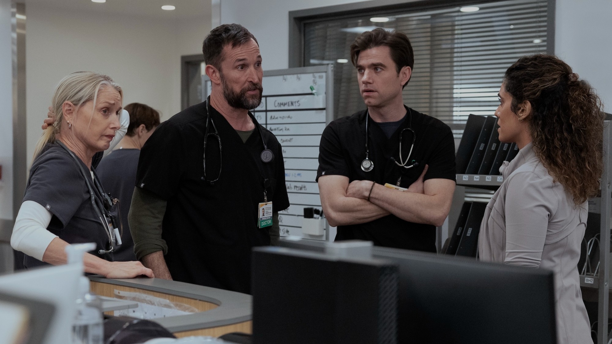 From left to right: Katherine LaNasa, Noah Wyle, Patrick Ball and Sepideh Moafi are all standing together, looking concerned on The Pitt. 