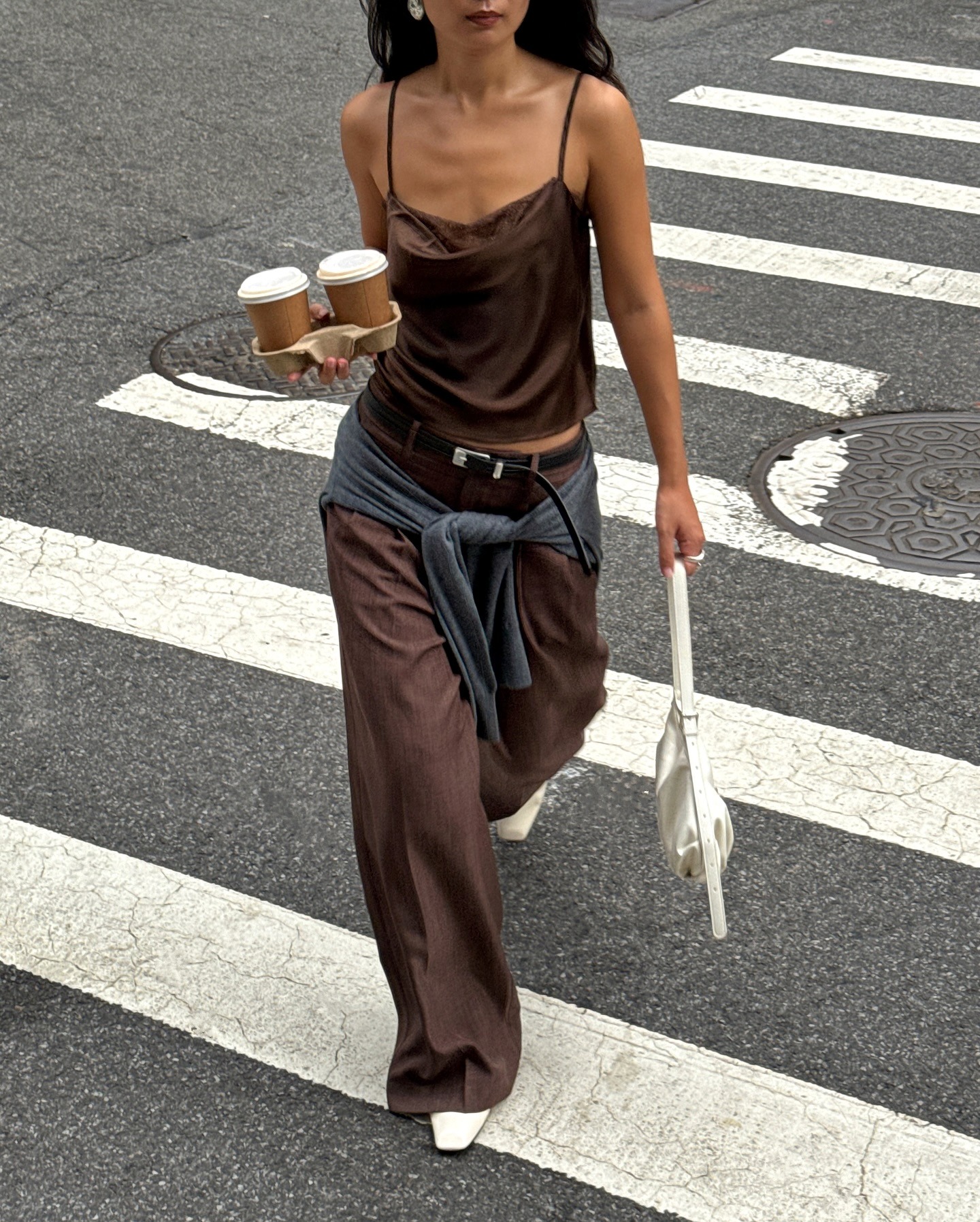 Influencer @thecarolinelin wears a satin top with brown trouser and white square-toe boots.