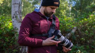 Cotton Carrier Skout G2 worn by a man in a burgandy jacket outdoors in a woods