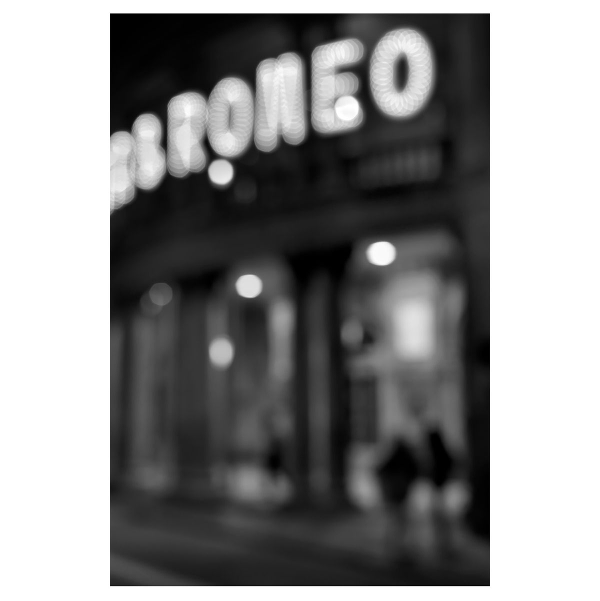 Black and white image of a blurry cinema sign captured on the streets of Barcelona