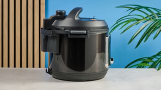 a black smart home enabled wi-Fi instant pot with a touchscreen and a 6QT inner pot is photographed against a blue background