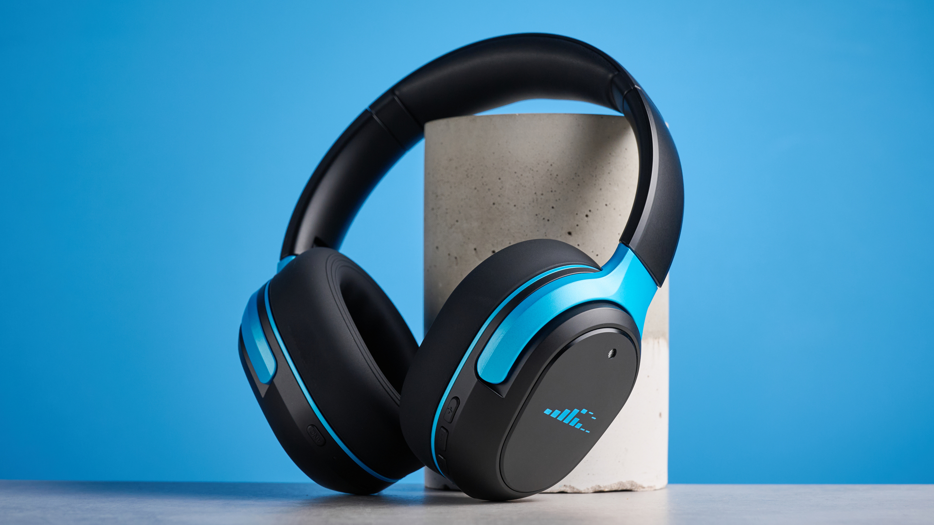 H2O RIPT Ultra headphones in black with blue accents photographed on a blue background