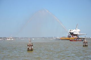 Houston fire boats offer a welcome salute to a space shuttle replica that arrived at the city's Clear Lake dock for delivery to Space Center Houston for public display on June 1, 2012.