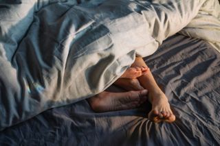 a couple's feet in bed - dating advice for women