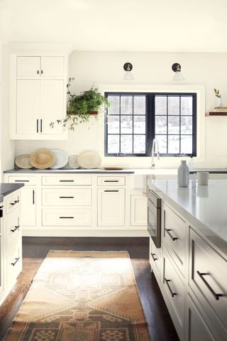 Cool toned white kitchen with a black window and black handles